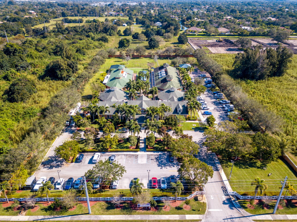 Country Inn Pet Resort and Animal Hospital campus, Davie, FL Aerial view of Country Inn Pet Resort and Animal Hospital's multi-building campus and parking areas surrounded by palm trees in Davie, FL